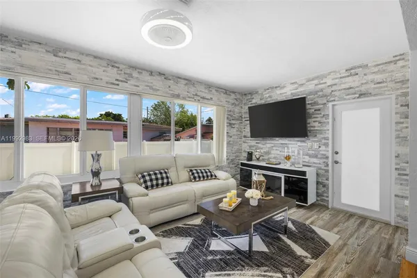 a living room with fireplace furniture and a large window