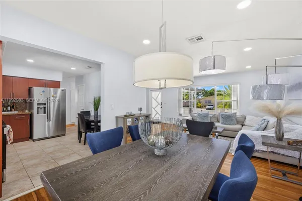 a dining room with stainless steel appliances granite countertop furniture and a kitchen view