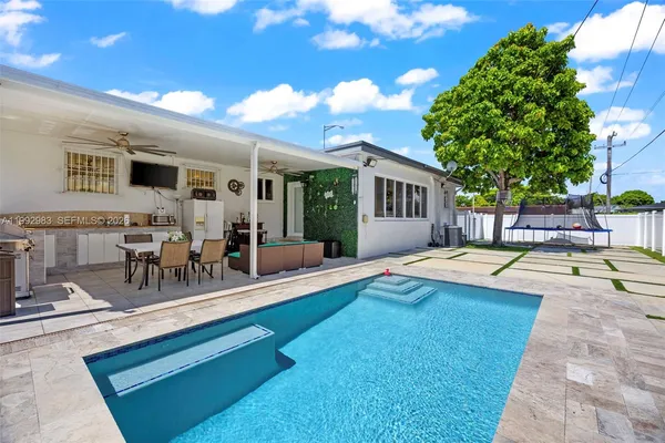 a view of a house with swimming pool and sitting area