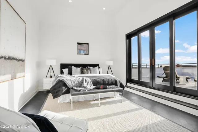 a bedroom with a bed and glass window