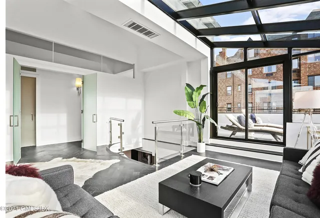 a living room with furniture and a floor to ceiling window