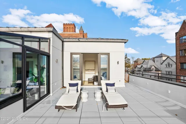 a living room with patio furniture and a large window