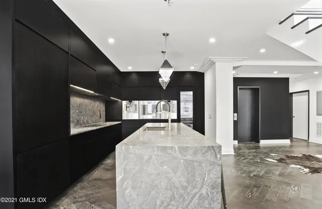 a kitchen with stainless steel appliances kitchen island granite countertop a refrigerator and a stove top oven