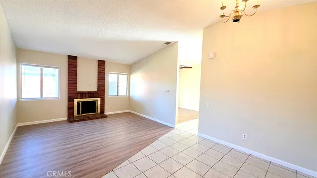 a view of a livingroom with wooden floor and a fireplace
