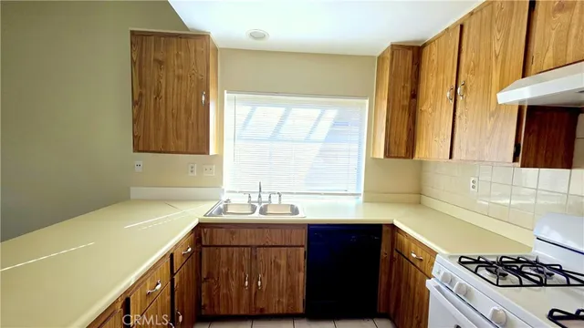 a kitchen with a sink a stove and cabinets