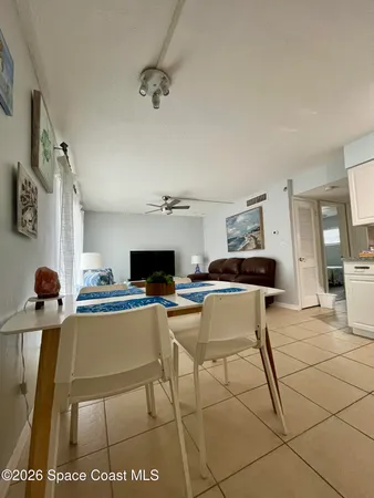 a living room with furniture a flat screen tv and kitchen view