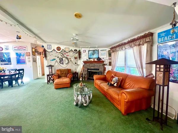 a living room with furniture a fireplace and a large window