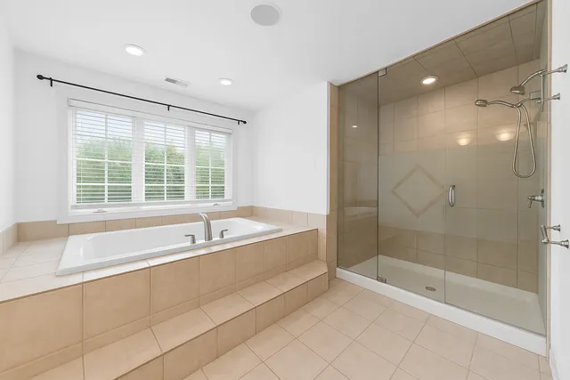 a spacious bathroom with a bathtub and a shower
