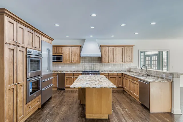 a kitchen with stainless steel appliances granite countertop a sink stove and refrigerator
