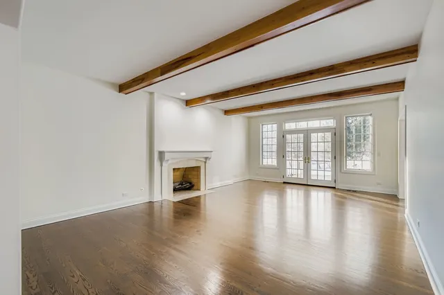 a view of empty room with wooden floor and fireplace