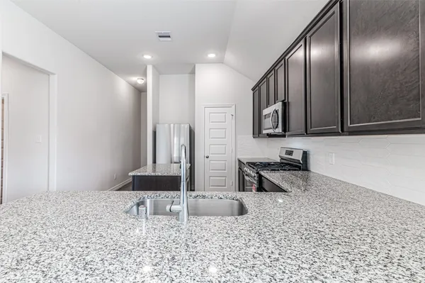 a kitchen with stainless steel appliances granite countertop a sink and stove
