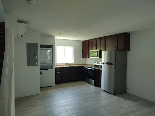 a kitchen with a refrigerator and a stove top oven