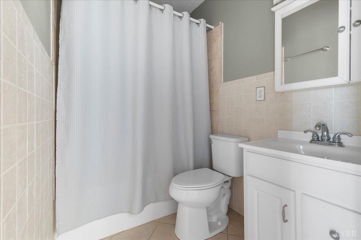 813 Doss Road Concord, VA 24538 - Photo 20 of 31 a bathroom with a sink a toilet and shower curtain