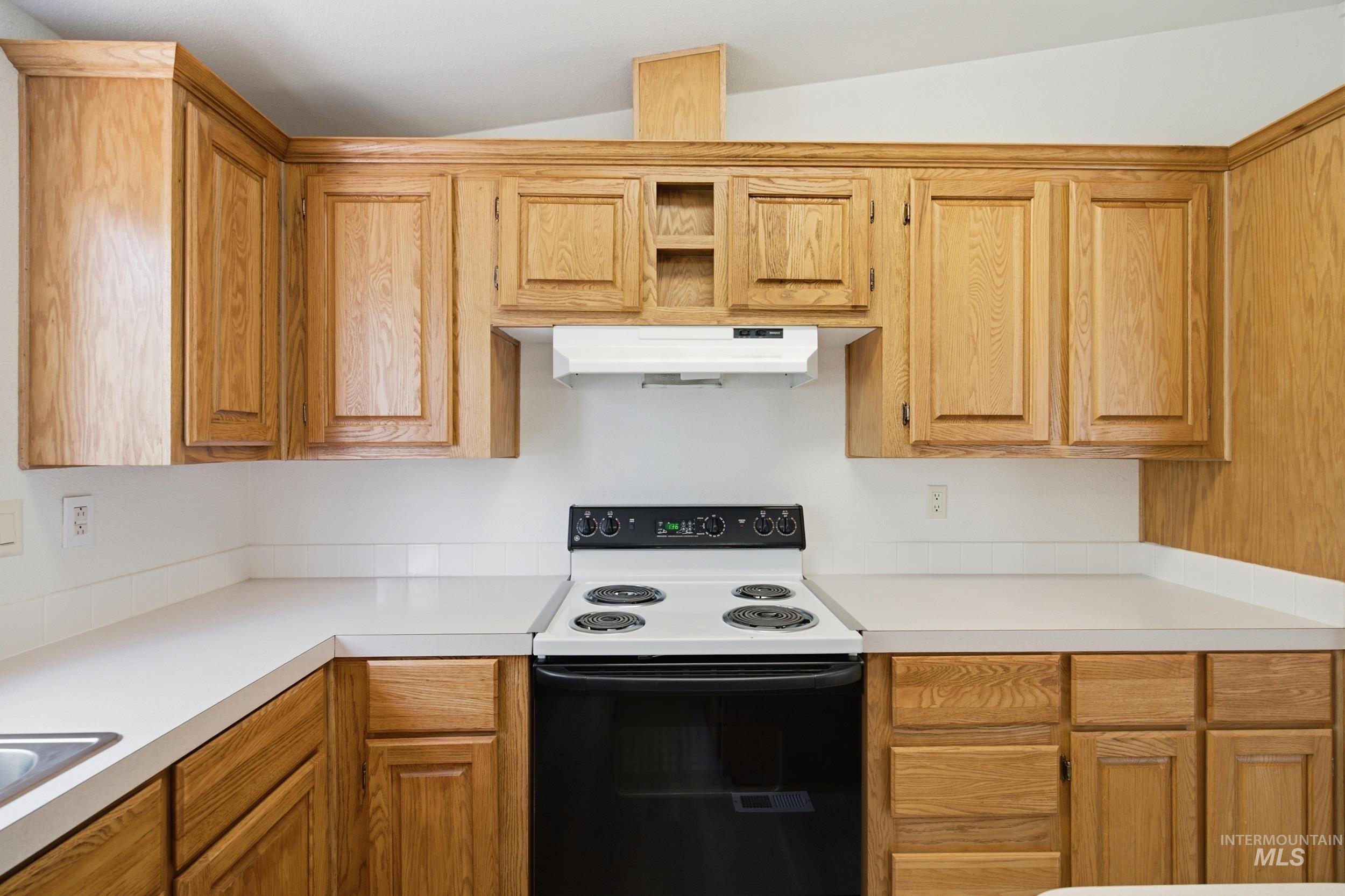 7422 Track Road Nampa, ID 83686 - Photo 9 of 50 Kitchen featuring extensive natural wood cabinetry, white countertops, built-in range, and a white range hood