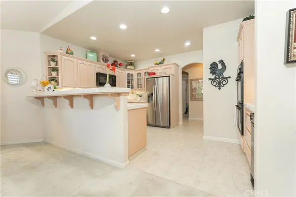 a kitchen with stainless steel appliances kitchen island granite countertop a refrigerator and a sink