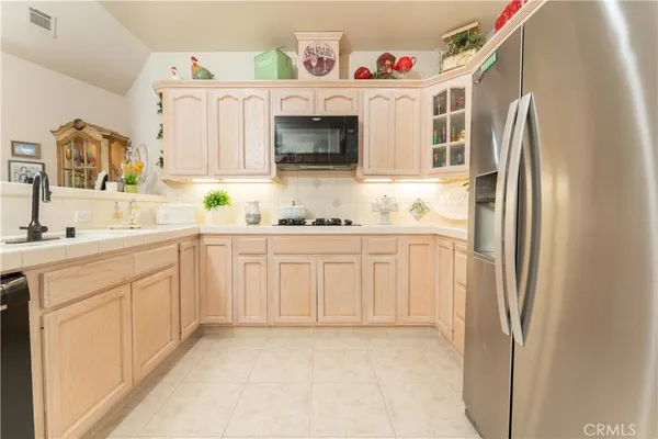 a counter top with a stove a microwave and cabinets