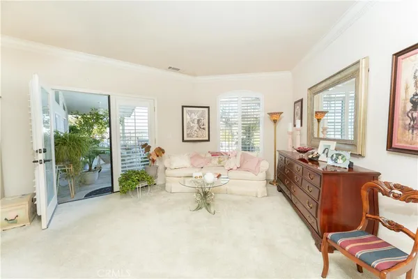 a living room with furniture potted plant and paintings on the wall