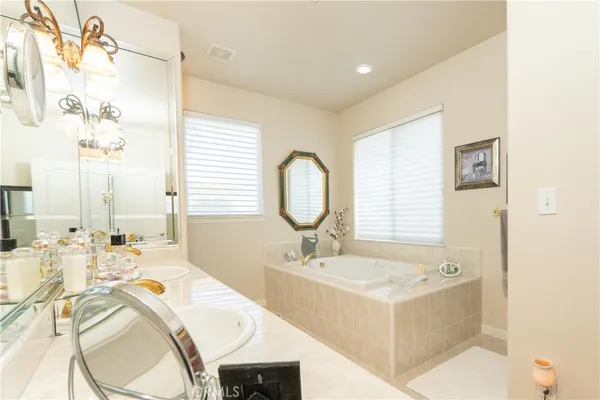 a spacious bathroom with a double vanity sink mirror and a bathtub