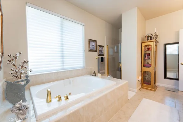 a bathroom with a tub sink and mirror
