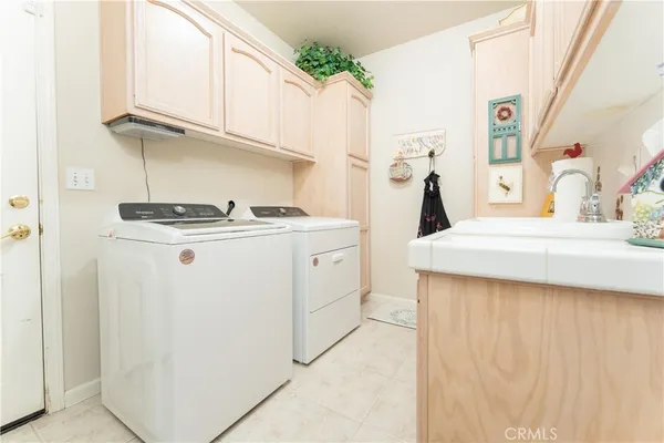 a kitchen with white cabinets and sink