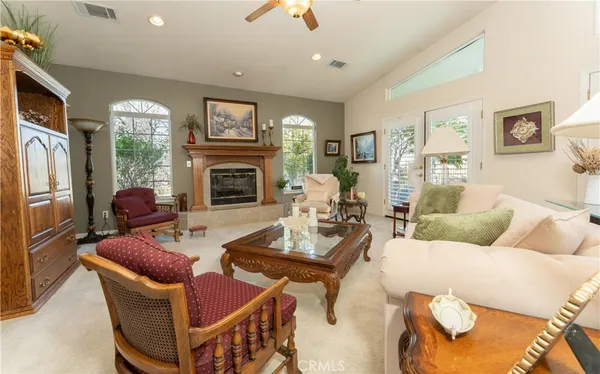 a living room with furniture a fireplace and a chandelier