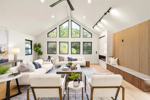 a living room with furniture a table and a large window