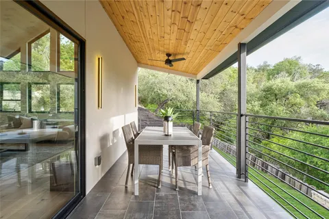 a view of a porch with a floor to ceiling window and a table