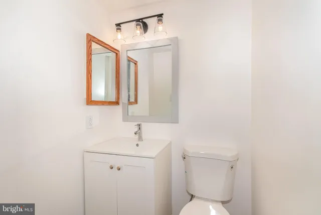 a bathroom with a toilet a sink and mirror