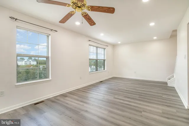 wooden floor in an empty room with a window