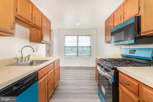 a kitchen with stainless steel appliances granite countertop a sink stove and cabinets