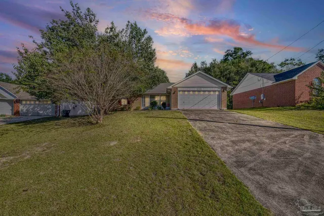 a front view of a house with a garden and yard