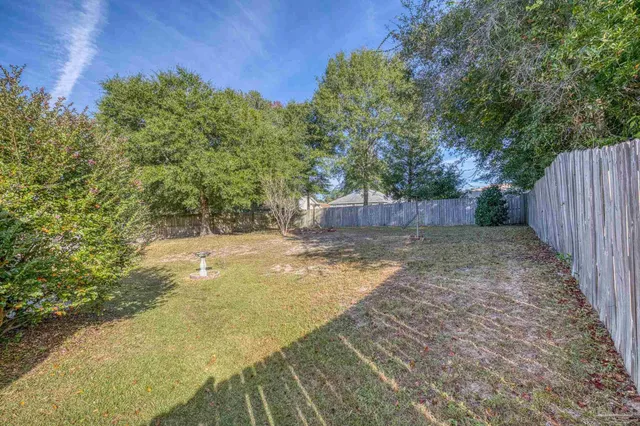 a backyard of a house with a fountain and large tree