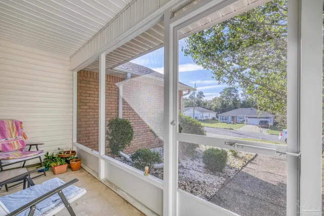 a view of a porch with furniture and floor to ceiling windows