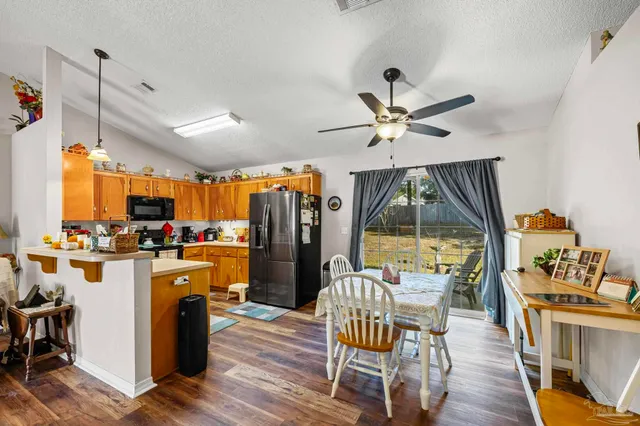 a dining room with furniture a chandelier and wooden floor