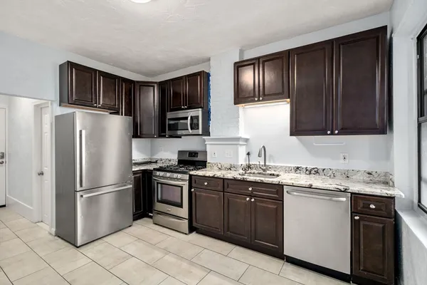a kitchen with stainless steel appliances granite countertop a refrigerator stove a sink and dishwasher
