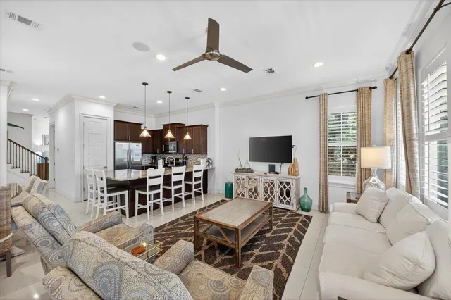 a living room with furniture kitchen view and a large window