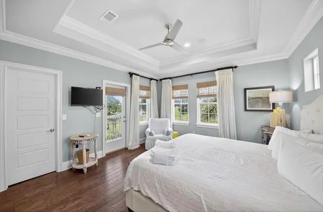 a bedroom with a bed flat screen tv and a large window