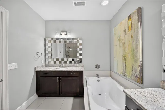 a bathroom with a tub sink and mirror
