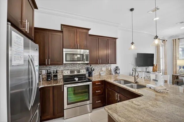 a kitchen with stainless steel appliances granite countertop a sink refrigerator and microwave