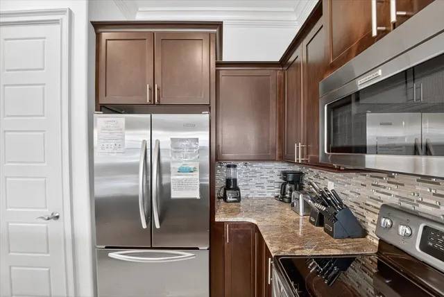 a kitchen with stainless steel appliances granite countertop a refrigerator a stove and a sink with wooden floor