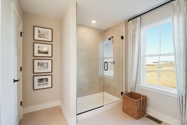 a bathroom with a tub shower and mirror