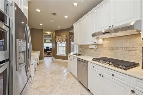 a kitchen with stainless steel appliances granite countertop a stove and a refrigerator