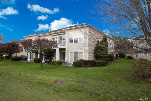 a view of a white house with a big yard