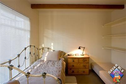 7671 Quartz Road Mojave, CA 93501 - Photo 5 of 10 a bedroom with a bed and a chandelier
