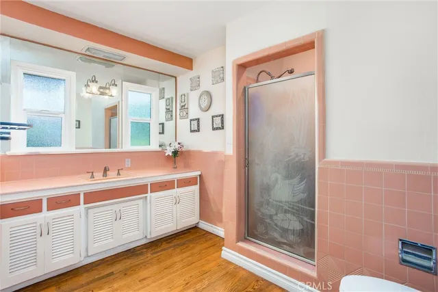 a spacious bathroom with a double vanity sink a mirror and a shower