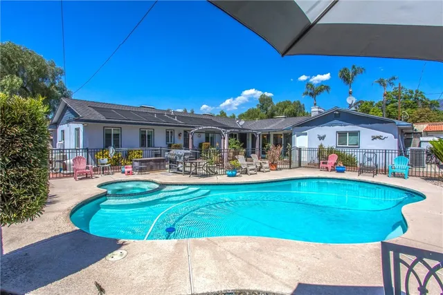 a front view of a house with swimming pool having outdoor seating