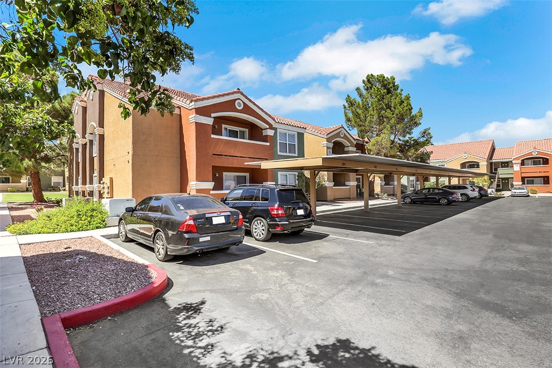 8101 West Flamingo Road, Unit 2136 Las Vegas, NV 89147 - Photo 2 of 32 Stucco exteriors and Spanish tile roofs define this residential community featuring covered parking options.