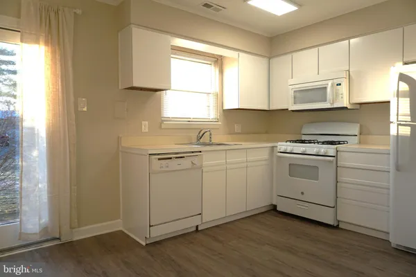 a kitchen with white cabinets and white appliances
