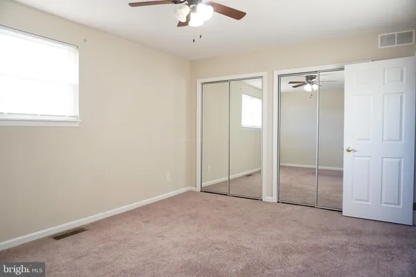 an empty room with fan and windows