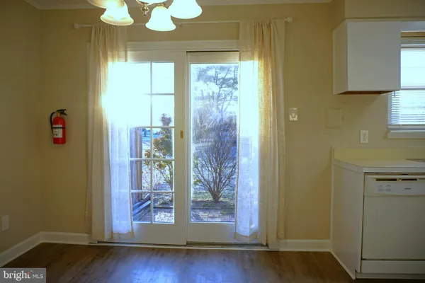 a view of a hallway with wooden floor and door